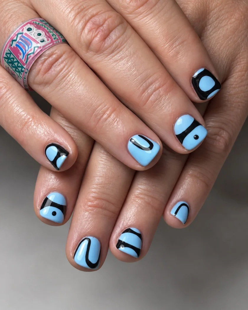 Lichtblauwe nagels met zwarte abstracte lijnen
