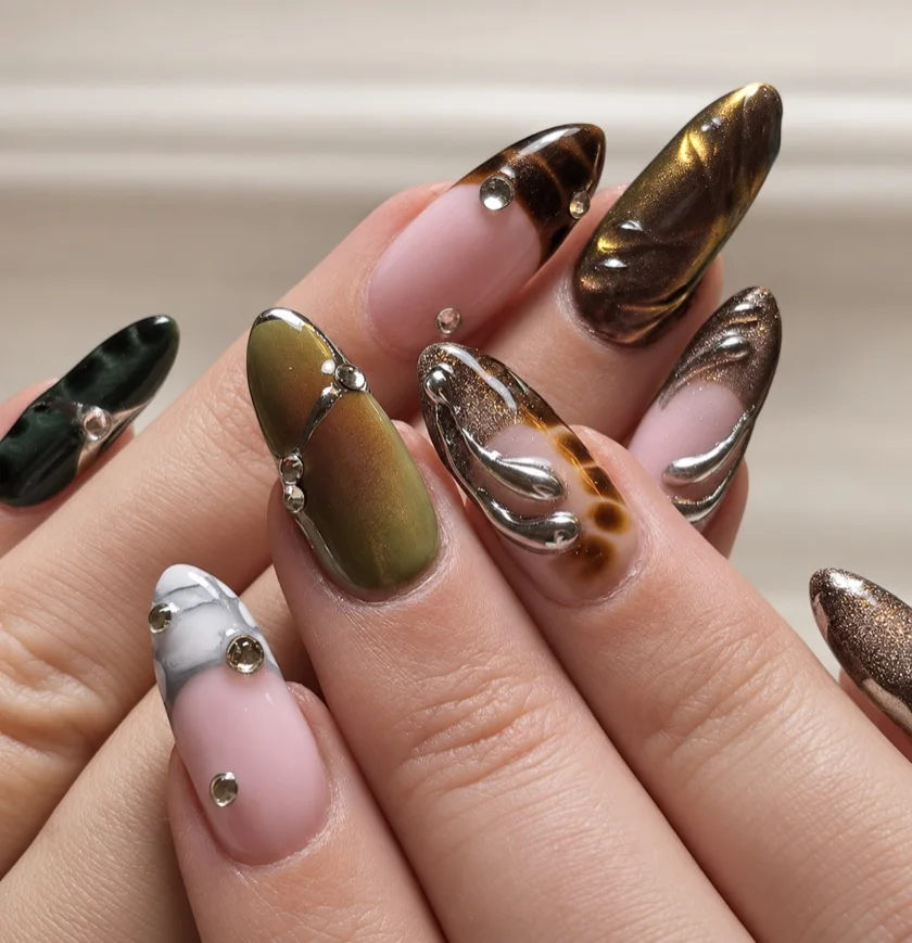 Olijfgroene, bruine en nude nagels met tortoise, zilverkleurige lijnen in reliëf en steentjes